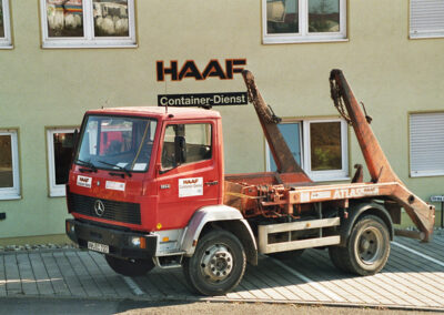 Roter Absetzkipper-LKW steht vor dem HAAF Firmengebäude.