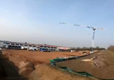 Baustelle mit Kran und bereits angelegten Erdflächen und Zufahrten für die Hallen des HAAF Containerdienstes.