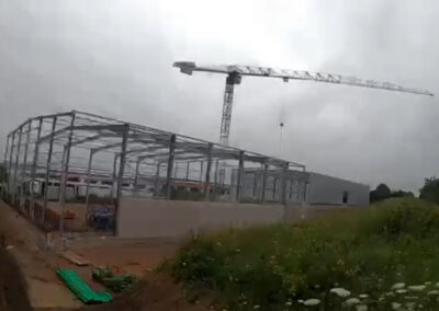 Baustelle mit Kran und im Aufbau befindlicher Stahlkonstruktion für eine große Halle am Wachtelberg 14 in Kürnach.