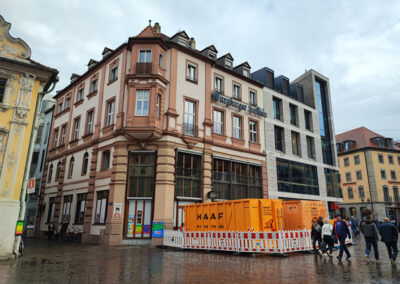 Großer HAAF-Container steht in einer abgesperrten Zone vor historischen und modernen Gebäuden in der Innenstadt.